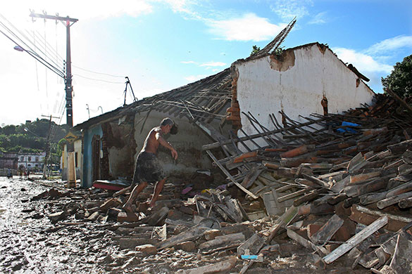 Floods in Brazil: A man walks through the debris of his house 