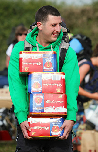 Glastonbury arrivals: A man carries beer
