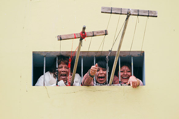 24 hours in pictures: Inmates celebrate a goal through their cell window in Lima
