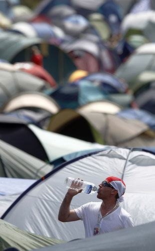 Glastonbury fans: An England fan drinks water among the tents at the Glastonbury Festival