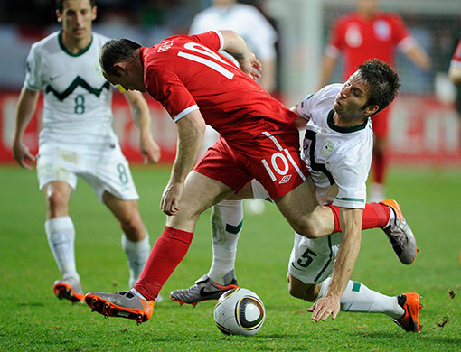 slovenia versus england: Wayne Rooney gets tackled