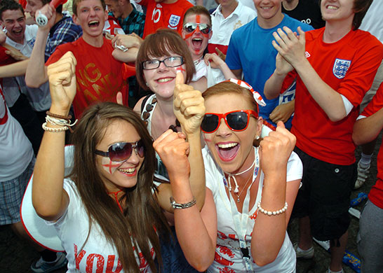 England fans: Castlefield Basin, UK: People celebrate in a park in Manchester