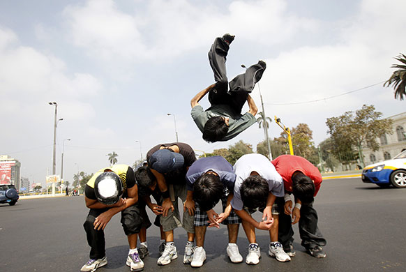 24 hours : A group of dancers somersault at a traffic junction in Lima