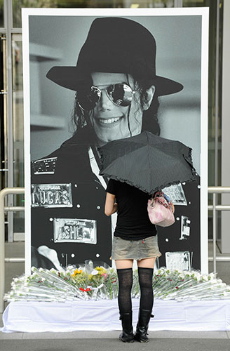 Michael Jackson memorials: A Japanese fan prays in front of a large portrait of Michael Jackson