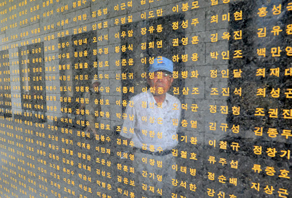 Korean war anniversary: A South Korean veteran looks at the names of fellow soldiers