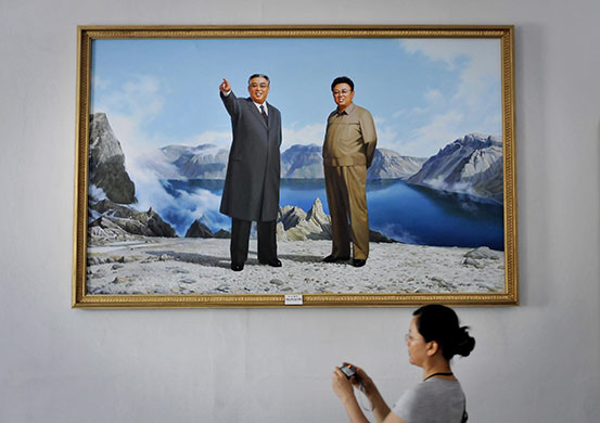 24 Hours: A tourist photographs a painting of Kim Jong Il and his father Kim Il Sung