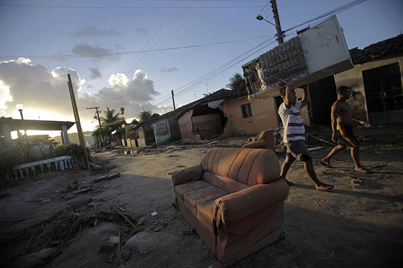 24 Hours: A man salvages belongings near damaged houses in Rio Largo city