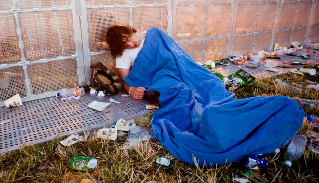 Day Four: A festival goer sleeps in front of the Pyramid Stage