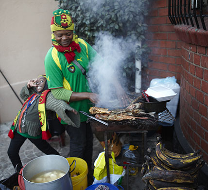 African fans in Jo'burg: Fish and plantains are prepared outside a bar ahead of the match