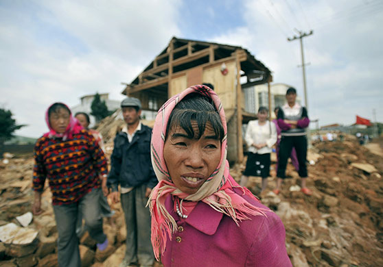 24 hours in pictures: Malong county, China: Local villagers in front of their destroyed houses