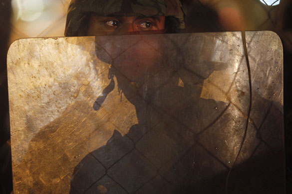 24 hours in pictures: A soldier watches a protest rally held by supporters of ousted president Manuel Zelaya