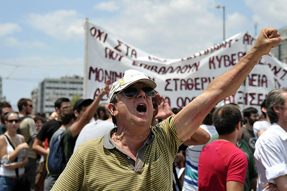 Greece protests: A protesters shouts in front of the parliament in the centre of Athens