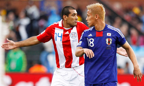 Paraguay's Paulo da Silva reacts beside Japan's Keisuke Honda