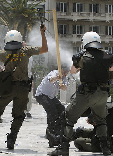 Greek protests: A protester attacks policemen with a wooden pole 