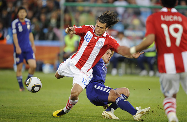 Paraguay v Japan: Nelson Valdez is tackled by Yuichi Komano