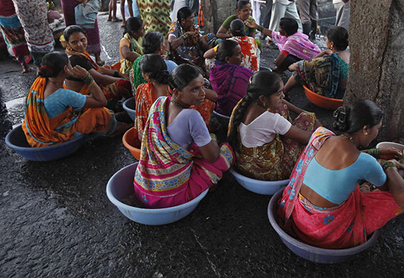 24 hours: Mumbai, India: Labourers wait for boats to unload fish at a harbour