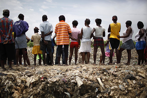24 hours: Port-au-Prince, Haiti: People watch the search for the body a man