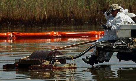 Contract workers from BP  use skimmers to clean oil from a marsh in Louisiana. 