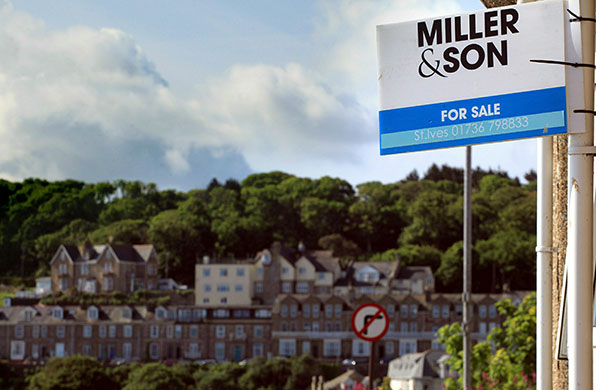 Week in Business: An estate agents for sale sign in front of a house in St Ives, Cornwall.