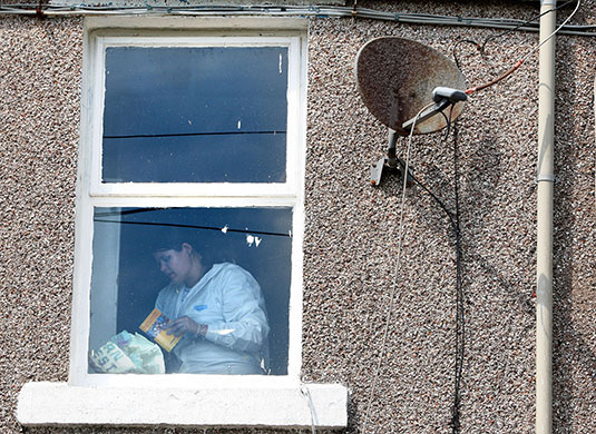 Cumbria shootings: Photographs are removed from a cupboard inside Derrick Bird's house