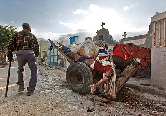 Press Photographer's Year: A man walks past a barrow laden with corpses in Port-au-Prince