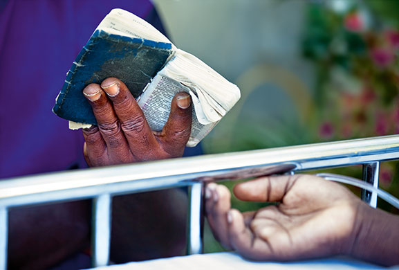 Press Photographer's Year: The father of a child lying injured reads a bible in Haiti
