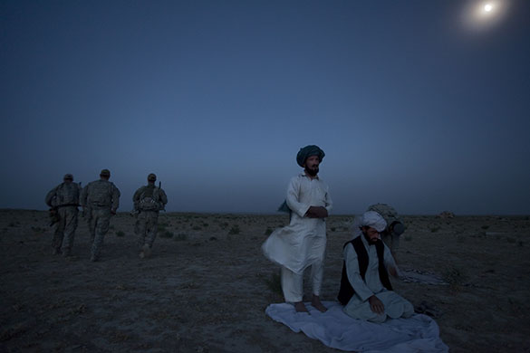 Press Photographer's Year: Village elders kneel to pray in a break during talks with soldiers