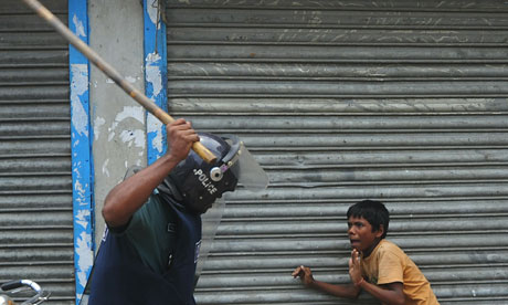 A Bangladeshi policeman threatens a child