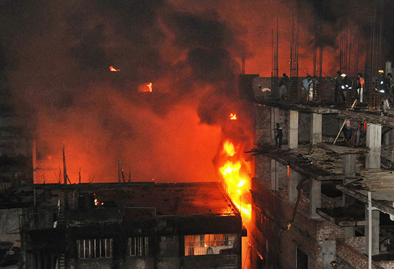 Dhaka fire: Firefighters and bystanders try to extinguish fire