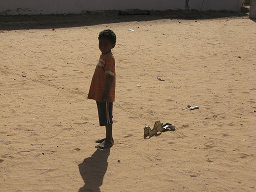 Kids for Kids: A boy stands alone with his handmade toy