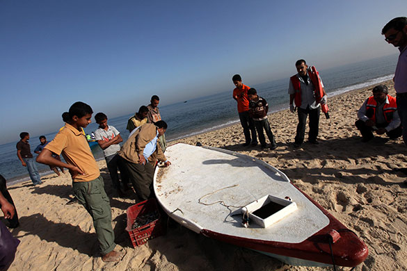 Israeli navy kills four: Palestinians inspect the boat of four Palestinian militants
