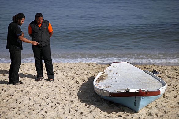 Israeli navy kills four: Palestinians look at a boat used by Palestinian militants