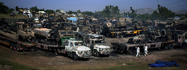 Pakistan convoy attack: Local residents examine burnt trucks torched by suspect militants