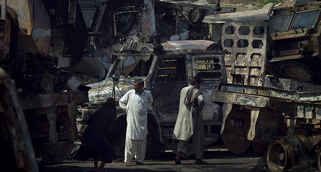 Pakistan convoy attack: Drivers examine the burnt trucks
