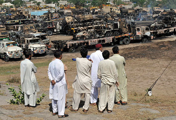 Pakistan convoy attack: Truck owners gather near the burnt out wreckage of NATO supply trucks
