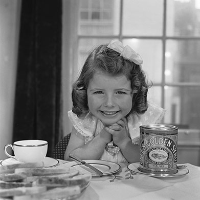 Tate & Lyle: 1957: A little girl grins at the prospect of Tate & Lyles Golden Syrup