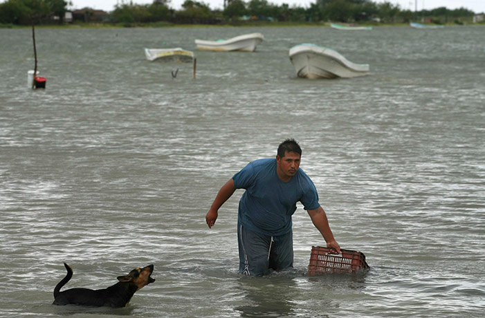Hurricane Alex: A man hauls a box to shore in preparation for the arrival of Hurricane Alex