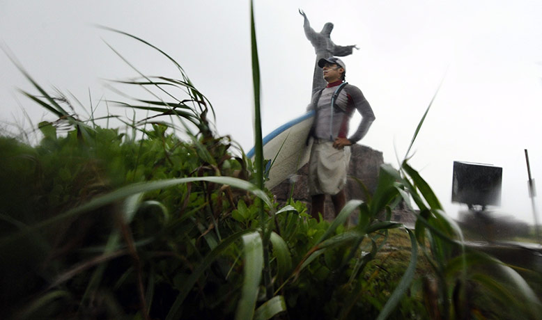 Hurricane Alex: A man prepares to go surfing on the waves produced by Hurricane Alex