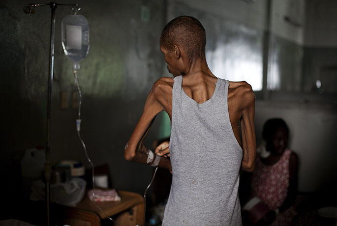 24 Hours: A patient adjusts his intravenous line at a hospital in Port-au-Prince