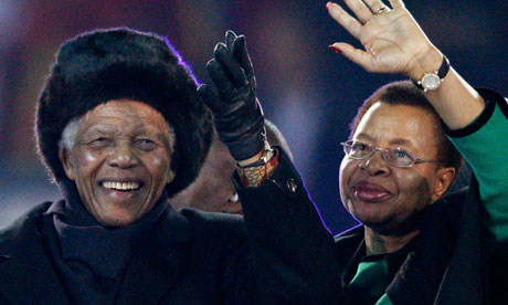 Nelson Mandela and his wife Graca Machel wave to fans at Soccer City stadium