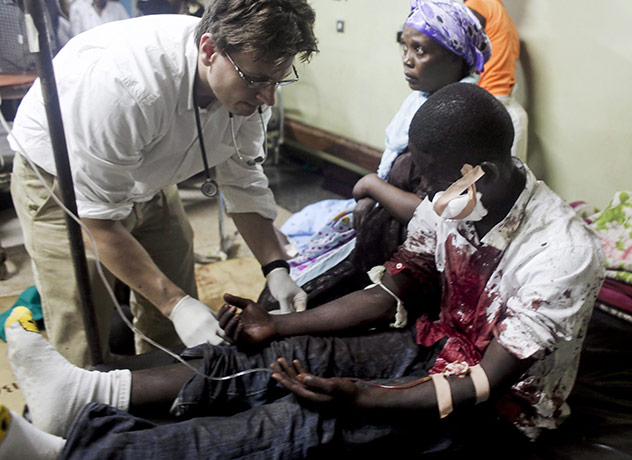 Uganda explosion: An injured man is treated by a doctor at Mulago Hospital, Uganda