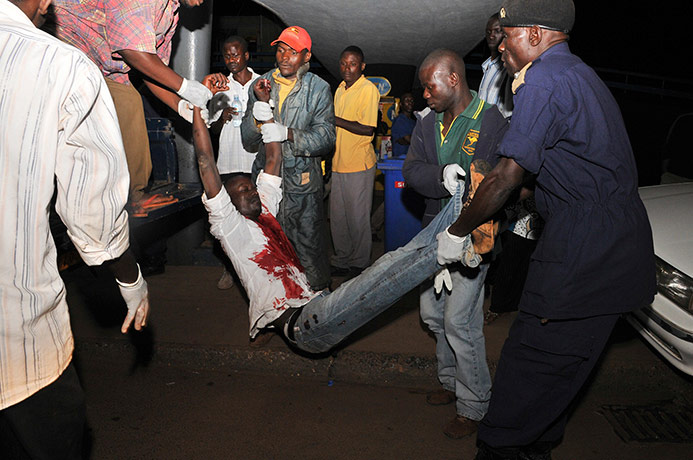 Uganda explosion: People carry a man injured in an explosion at the Mulago Hospital