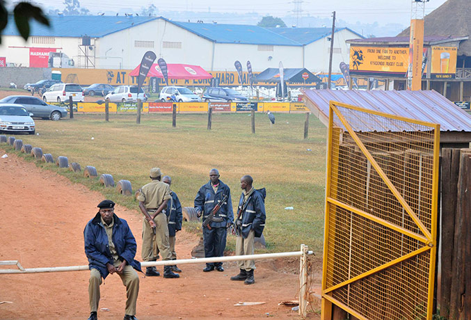 Uganda explosion: Ugandan policemen stand at the entrance of the site of attacks in Kampala
