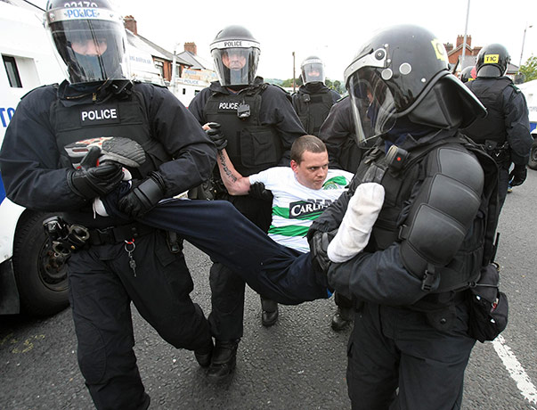Belfast riots: Police remove a nationalist protester before an Orange Order march