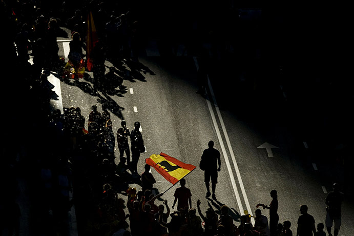24 hours pictures: A supporter waves a Spanish flag waiting for Spain's football team