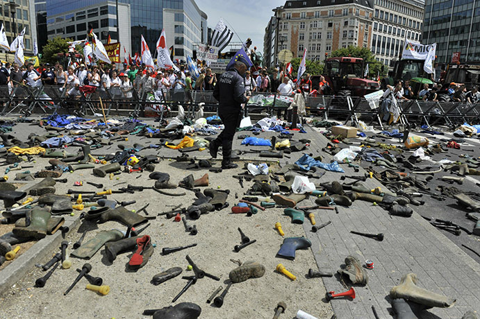 24 hours pictures: Police walk among boots thrown by milk producers, Brussels, Belgium