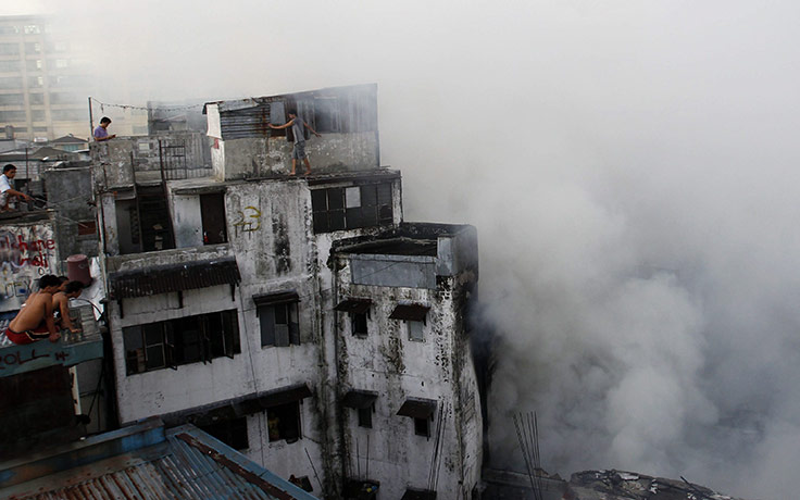 24 hours pictures: People watch a fire at a residential building, Philippines