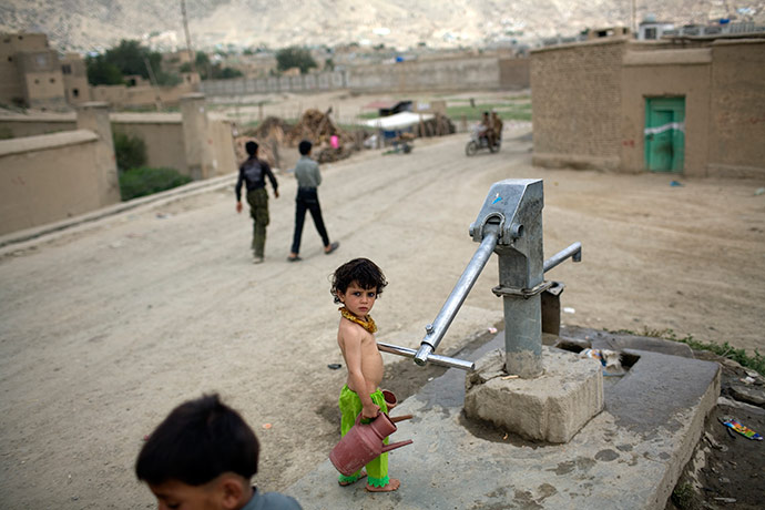 24 hours pictures: A girl prepares to fill a pitcher with water Kabul, Afghanistan