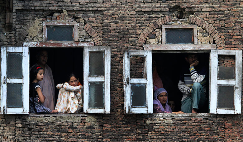 24 hours pictures: Kashmiri families at windows of their houses on Martyr's Day