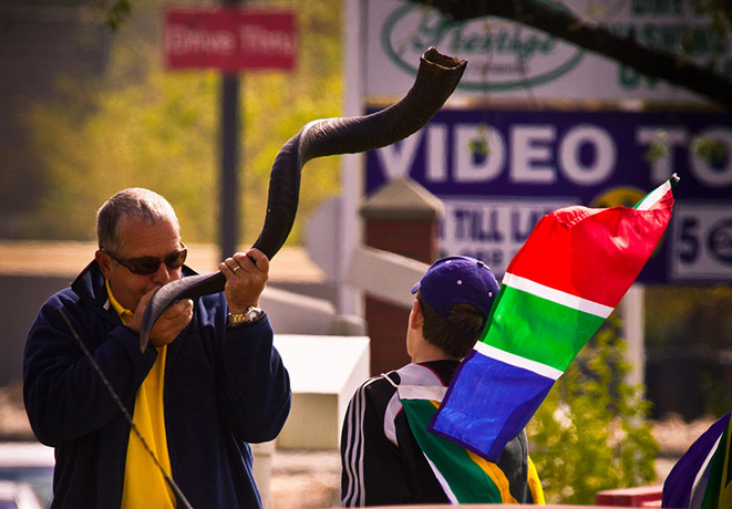 Fans' network: Man blowing a curly vuvuzela